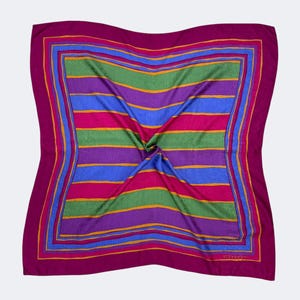 Puede incluir: Un pañuelo cuadrado con un vibrante estampado de rayas. El pañuelo presenta bandas horizontales de color rosa, verde, azul y morado, bordeadas por un marco magenta oscuro. Los detalles dorados resaltan los bordes, creando un accesorio colorido.