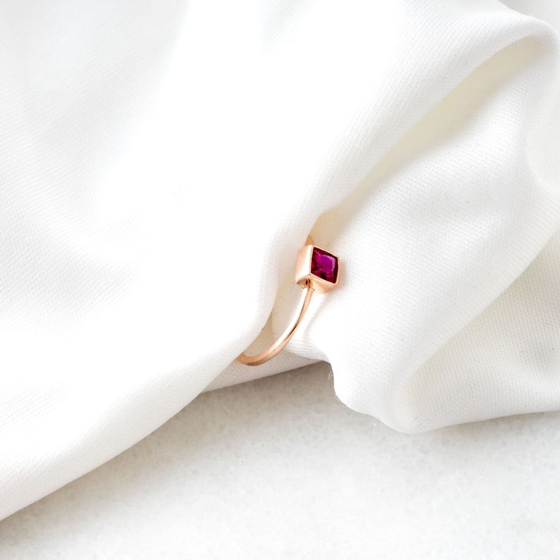 Op de afbeelding: Een ring van ros&eacute;goud met een vierkante robijn.