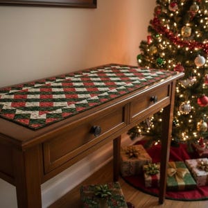 Puede incluir: Una consola de madera con dos cajones, cubierta con un camino de mesa acolchado con un patrón geométrico rojo, verde y blanco. Un árbol de Navidad decorado se encuentra en el fondo, con regalos envueltos debajo.