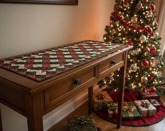 Peut inclure: Une console en bois à deux tiroirs, surmontée d'un chemin de table matelassé à motifs géométriques rouges, verts et blancs. Un sapin de Noël décoré se dresse en arrière-plan, avec des cadeaux emballés en dessous.