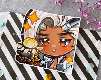 May include: A sticker featuring a cartoon character with white hair, brown skin, and large brown eyes. The character is wearing a white and blue outfit and holding a golden object. The sticker has a sparkly effect and the text "by inntary" is visible in the bottom left corner.