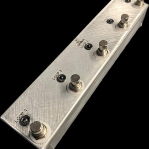 Könnte beinhalten: Ein silbernes Metall-Pedalboard mit vier Fußschaltern, die mit "LOOP 1", "LOOP 2", "LOOP 3" und "LOOP 4" beschriftet sind.