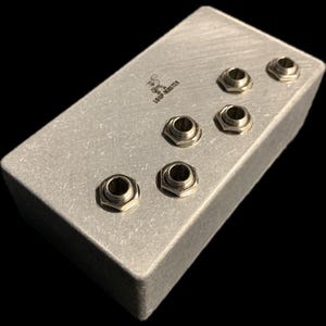 May include: A silver metal box with six 1/4 inch jacks, labeled "Loop Master".