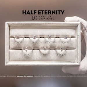 a collection of six diamond engagement rings, each with a unique cut and shape, presented in a white display case.