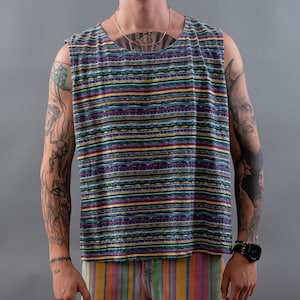 Könnte beinhalten: Ein ärmelloses Top und Shorts mit farbenfrohem Streifenmuster. Das Top hat einen quadratischen Ausschnitt und die Shorts haben einen rohen Saum. Das Outfit wird mit schwarz-weißen Turnschuhen kombiniert.