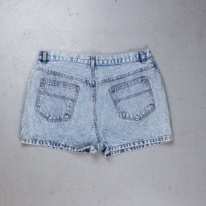 Pode incluir: Shorts de ganga azul claro com um aspeto desbotado e dois bolsos traseiros.
