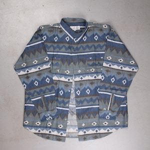 May include: A long-sleeved button-down shirt with a blue, white and brown geometric pattern. The shirt has a pointed collar and a single chest pocket.