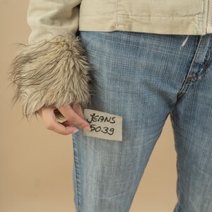 Może przedstawiać: Jasne niebieskie dżinsy z białą karteczką przyklejoną z przodu, na kt&oacute;rej napisano "Jeans 5039".