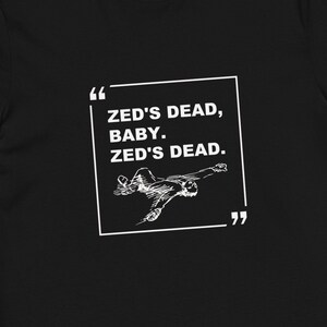 May include: Black t-shirt with a white graphic print of a person lying down with the text "ZED'S DEAD, BABY. ZED'S DEAD."