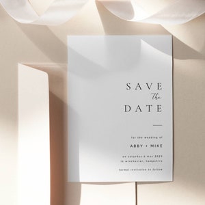 Puede incluir: Una tarjeta blanca de guardar la fecha con texto negro. El texto dice "Save the Date" para la boda de Abby + Mike el sábado 6 de mayo de 2025 en Winchester, Hampshire. Invitación formal a seguir.