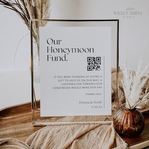 Könnte beinhalten: Ein weißes Schild in einem goldenen Rahmen mit dem Text "Our Honeymoon Fund." und einem QR-Code. Der Text unter dem QR-Code lautet "Wenn Sie daran gedacht haben, ein Geschenk zu machen, um uns auf unserem Weg zu helfen, wäre ein Beitrag zu unseren Flitterwochen eine große Freude. Vielen Dank! Emma & Noah 17.05.25".
