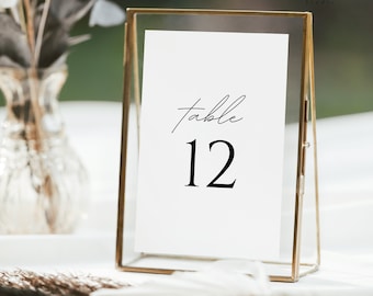 May include: A gold-framed table number card with the text "table 12" in black font.