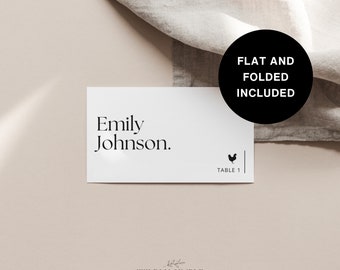 May include: White wedding place card with black text that reads "Emily Johnson."  The card also has a small black chicken icon and the text "Table 1".