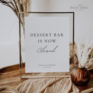 May include: A gold-framed sign with the text "Dessert Bar is Now Closed" and the names "Cecilia & Thomas" and the date "17.05.2025".