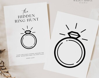 May include: Two white cards with black text and ring illustrations. One card reads "The Hidden Ring Hunt" with instructions and "Good Luck!". The other card features a diamond ring illustration. The cards are on a light background.