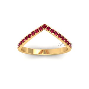 May include: A gold ring with a V-shaped band of red gemstones.