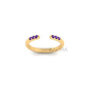 May include: A gold ring with a split band and a row of purple amethyst gemstones.