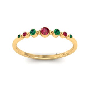 May include: A gold band ring with alternating red and green gemstones. The ring has a delicate design and is perfect for everyday wear.