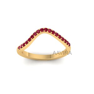May include: A gold band ring with a curved design, set with small red gemstones.