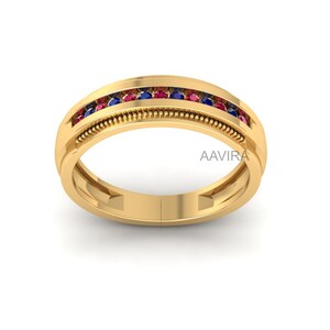 May include: A gold band ring with a row of red and blue gemstones. The ring has a textured band.