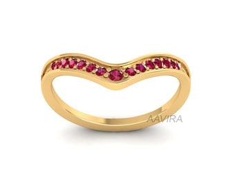 May include: A gold band ring with a V-shaped row of red gemstones.