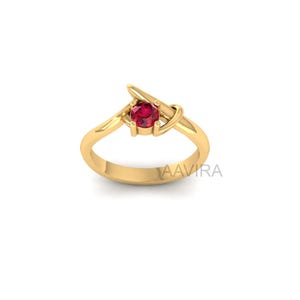 May include: A gold ring with a red gemstone set in a unique, abstract design.