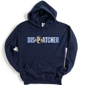 May include: A navy blue hooded sweatshirt with a yellow and blue graphic of a headset and the word "DISPATCHER" printed on the front.