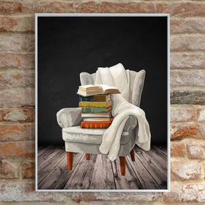 May include: A framed print featuring a gray armchair with a stack of books and a white blanket draped over it. The books are various colors, and the background is a dark gray. The chair sits on a wooden floor.