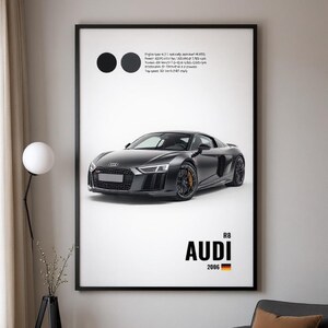 May include: A framed print featuring a black Audi R8 sports car. The image includes the text "AUDI R8 2006" with the German flag. Technical specifications are listed in the upper right corner, and two black circles are on the upper left.