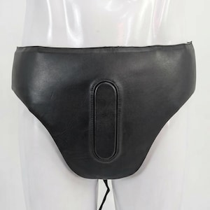 May include: Black leather protective athletic cup with a padded oval center. The cup is designed to be worn for protection during sports or other activities. It has a contoured shape and a drawstring closure.