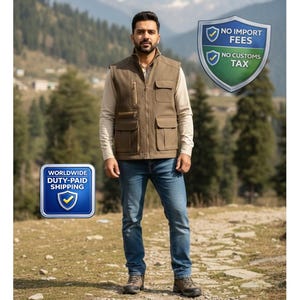 Puede incluir: Un hombre con un chaleco marrón con múltiples bolsillos, una camisa de manga larga de color claro, vaqueros azules y botas marrones. El chaleco tiene cierre de cremallera. El fondo presenta un paisaje montañoso.