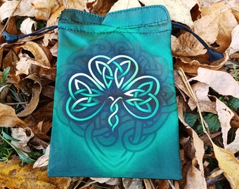 Puede incluir: Una bolsa de cordón verde con un diseño de trébol de nudo celta. La bolsa está hecha de un material suave y de tela.