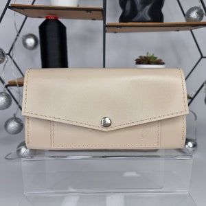 Cartera de piel brillante con botón "Sobre"