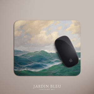 May include: A rectangular mousepad featuring a vintage painting of ocean waves in shades of teal and green under a cloudy sky. A black computer mouse with the Apple logo rests on the pad. The text "JARDIN BLEU VINTAGE ART" is at the bottom.