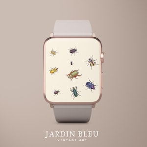 Könnte beinhalten: Eine roségoldene Smartwatch mit cremefarbenem Zifferblatt, das eine Vintage-Illustration von bunten Käfern zeigt. Die Uhr hat ein hellgraues Armband und den Text "JARDIN BLEU VINTAGE ART" am unteren Rand.