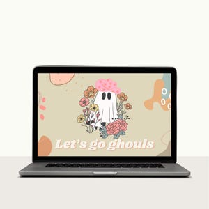 May include: A laptop computer screen displaying a digital illustration of a ghost wearing a pink flower crown and surrounded by flowers. The text "Let's go ghouls" is displayed on the screen.