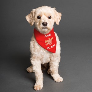 May include: A white dog wearing a red bandana with the text "GUNNER" and a gold cannon logo. The bandana also has the text "PET NAME" on it.