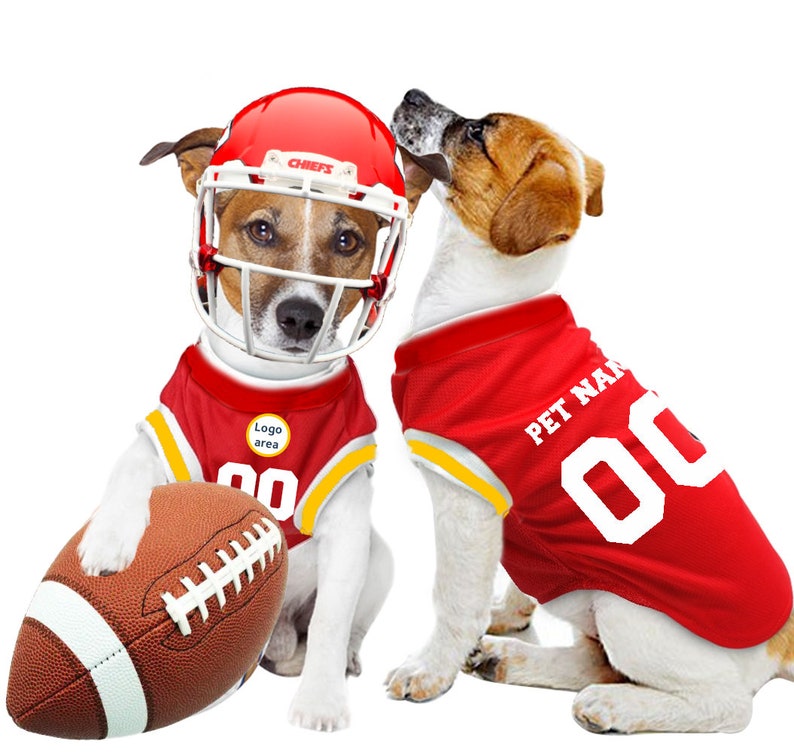 May include: Two dogs wearing red and yellow football jerseys. One dog is wearing a red helmet with the word "Chiefs" on it. The other dog is holding a brown football. The jerseys have the words "Pet Name" and "Logo Area" on them.
