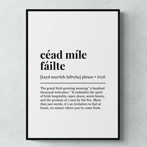 May include: A framed print with the Irish phrase "céad míle fáilte" in bold black letters. Below, the phonetic pronunciation and a definition: "a hundred thousand welcomes." The text embodies Irish hospitality.