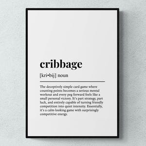 Könnte beinhalten: Gerahmter Druck mit der Definition von "cribbage" in schwarzem Text auf weißem Hintergrund. Die Definition enthält die Aussprache und eine Beschreibung des Kartenspiels. Der Rahmen ist schwarz.