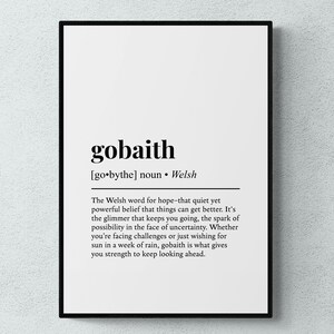Puede incluir: Impresión enmarcada con la palabra galesa "gobaith" y su definición en inglés. La impresión tiene un marco negro, un fondo blanco y texto negro. La definición describe "gobaith" como esperanza.