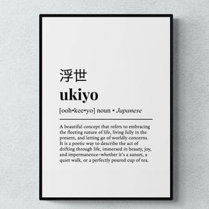 May include: A rectangular wall art print in a black frame featuring a white background with black text. The print displays the Japanese characters for ukiyo, the word ukiyo, its pronunciation, and a definition describing the concept of living in the present.