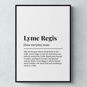 May include: A framed print with the words "Lyme Regis" in a bold, black font. Below, the phonetic pronunciation is given. The text describes Lyme Regis as a Dorset gem with fossils, novels, and seaside charm.