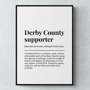 Op de afbeelding: Zwart ingelijste print met de tekst "Derby County supporter". De definitie wordt gegeven, inclusief de fonetische uitspraak en een beschrijving van een trouwe gelover in traditie en de geest van de Rams.