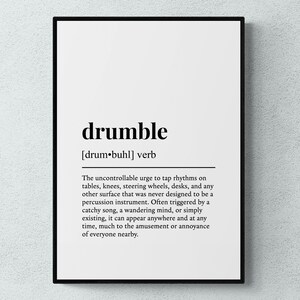 May include: A framed wall art print featuring a dictionary-style definition of the word drumble. The text is printed in black on a white background, defining the verb as the uncontrollable urge to tap rhythms on various surfaces like tables.