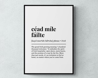 Op de afbeelding: Een ingelijste print met de Ierse uitdrukking "céad míle fáilte" in zwarte letters. De tekst bevat de fonetische uitspraak en een definitie: "honderdduizend welkomsten". Het belichaamt de Ierse gastvrijheid.