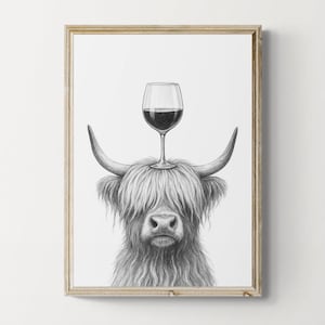 May include: Framed black and white print of a Highland cow with a wine glass balanced on its head. The cow has long, shaggy fur and curved horns. The wine glass is filled with red wine.