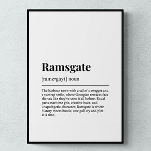 Puede incluir: Impresión enmarcada con la palabra "Ramsgate" en negrita negra, seguida de una pronunciación fonética y una definición. La definición describe Ramsgate como una ciudad portuaria con un carácter único.