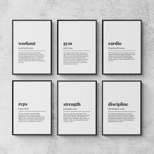 May include: Six framed prints with black frames and white backgrounds. Each print features a word in a bold font, such as "gym" or "strength", along with a definition. The prints are arranged in two rows of three.