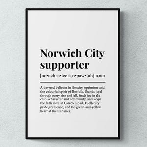 以下が含まれることがあります： 「Norwich City supporter」の文字が黒い太字で書かれた額入りのプリント。その下には、チームの熱心な信者を説明する定義があります。プリントは白い紙に黒いフレームで印刷されています。